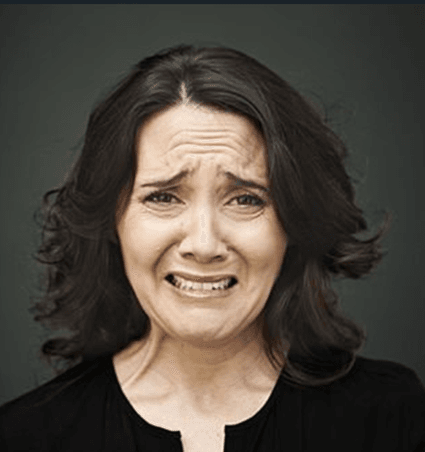 Lady with brown hair grimmacing