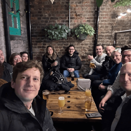 neurobox staff sitting down roudn a wooden table for a selfie