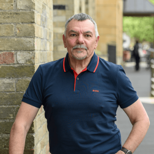 Larry, man wearing a dark blue polo standing in the street