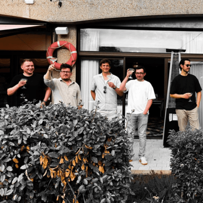 five young men, toasting with glasses of prosecco