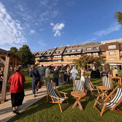large group of people in a sunny garden with deck chairs