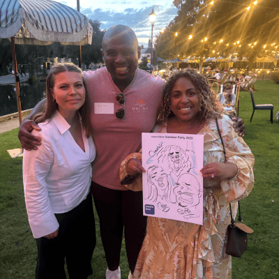 two females and a male taking a picture with their group caricature