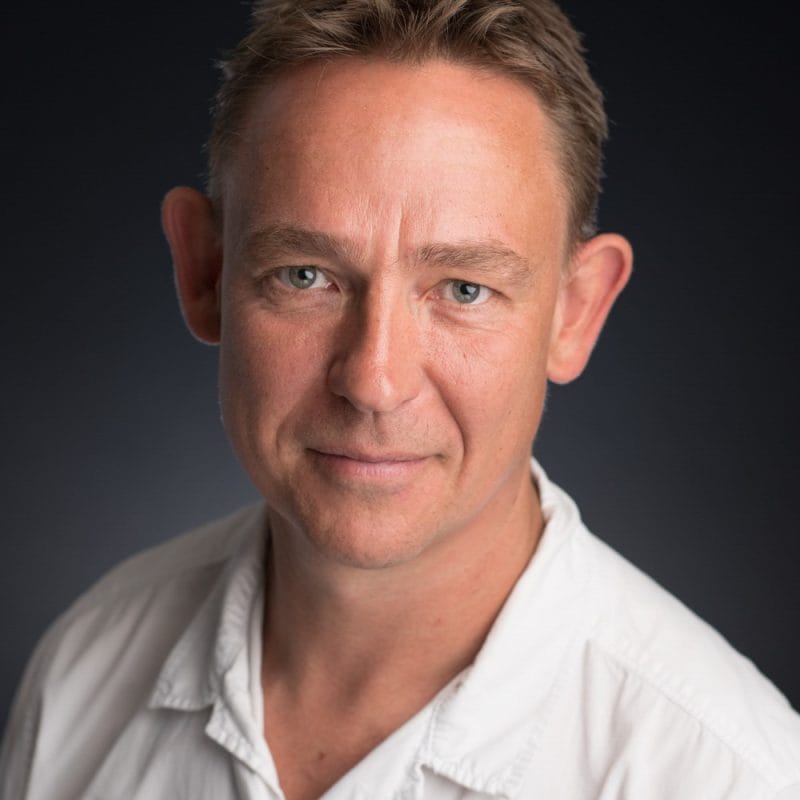 white male with short brunette hair wearing a white shirt