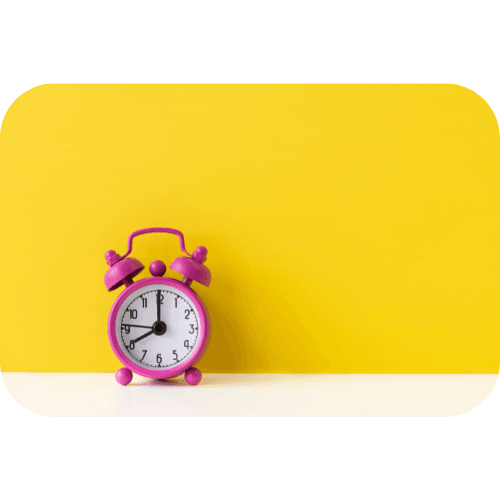 A pink alarm clock against a bright yellow alarm clock