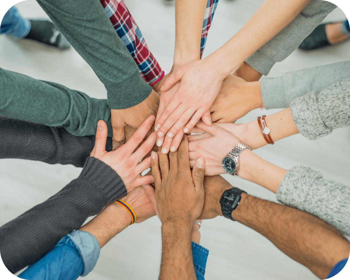 a large number of people reaching into a circle with their hands overlapping