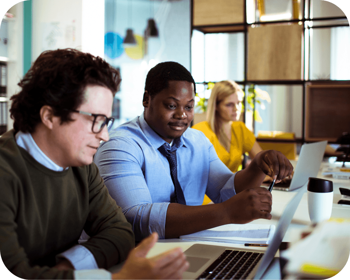 two office workers in shirts and ties, working together on one laptop