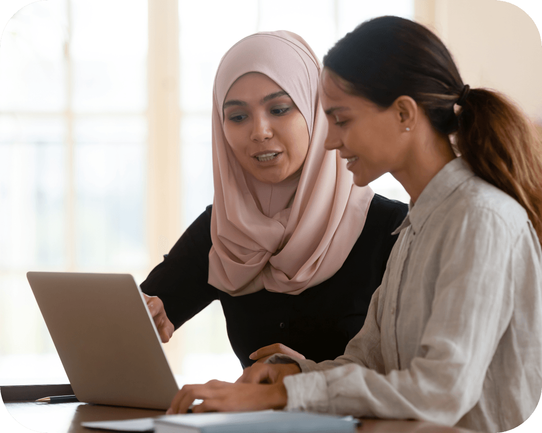 two female workers looking at a laptop screen